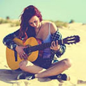 Woman playing guitar on the beach